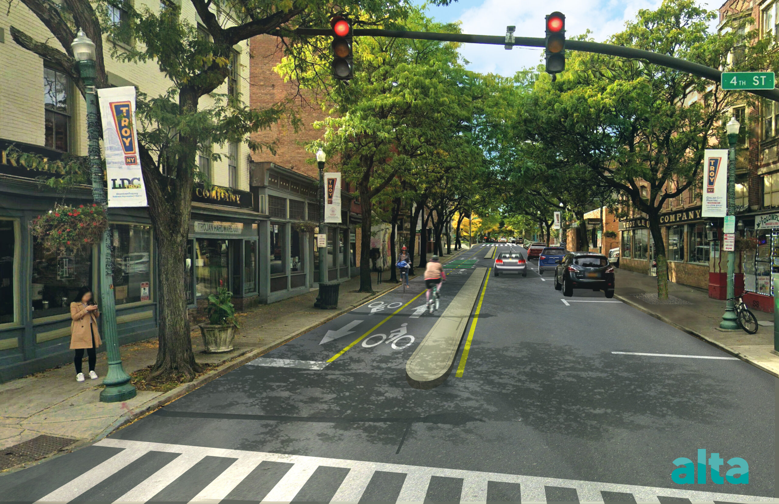 A view looking west from the intersection of Congress and 4th street. There is a two-lane bicycle path on the left side with a concrete medium to separate it from the one-lane car path. There is dedicated parking on the right side of the road.